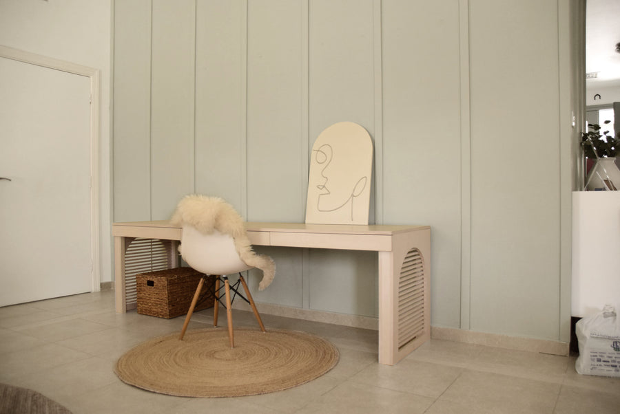 Low birch plywood desk with a slatted end panel in a home office
