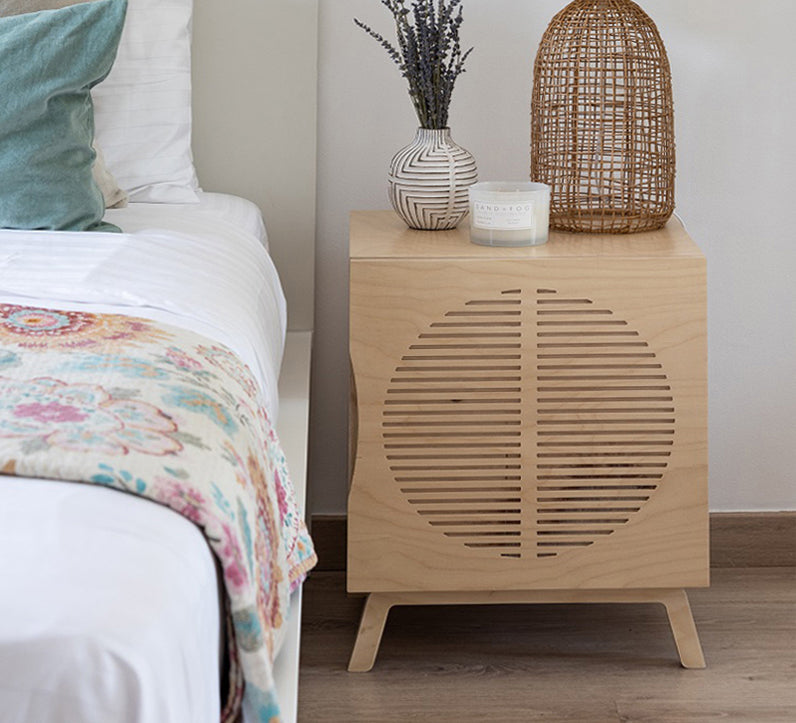 Penelope bedside table in birch plywood beside a made bed