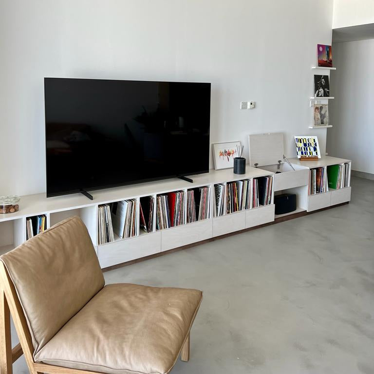 Made by Plyconcept: a long custom TV and vinyl record console in a white finish, with open record cubbies and a lift-up lid
