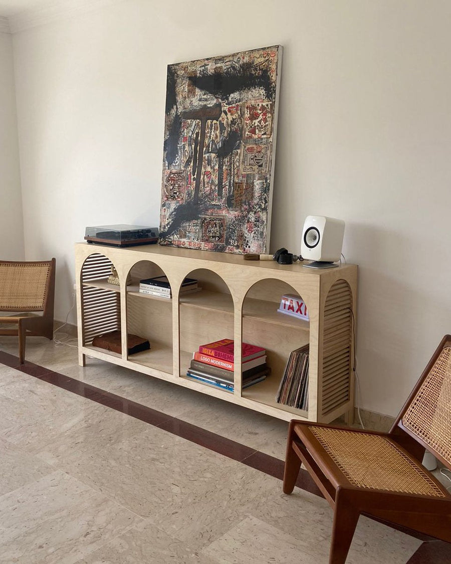 Jeffrey Sideboard, an open birch plywood sideboard with arched front, in a living room with two cane chairs