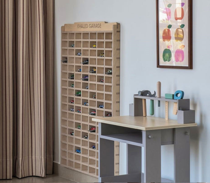 Wall-mounted wooden toy car garage in a room, displaying various toy cars.